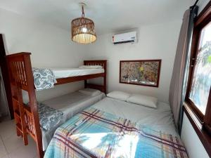 een slaapkamer met 2 stapelbedden en een raam bij Casa na Praia da Pipa próximo a Praia do Amor - RN in Pipa