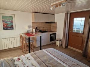 a kitchen with a table and a kitchen with a sink at Studio Bellevue appart indépendant rénové 2024 piscine parking proche centre Annecy in Poisy
