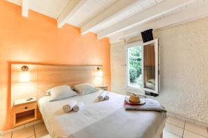 una camera da letto con un grande letto con asciugamani di SOWELL RESIDENCES Les Lauriers Roses a Cap d'Agde
