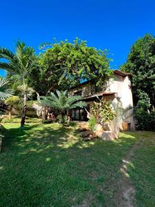 una casa en un patio con árboles y césped en Casa na Praia da Pipa próximo a Praia do Amor - RN, en Pipa