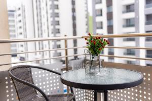 szklany stół z wazą z kwiatami na balkonie w obiekcie Pastel Apartments w Braszowie