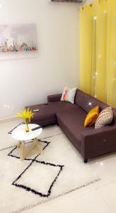 a brown couch in a living room with a table at Sweet home in Dakar