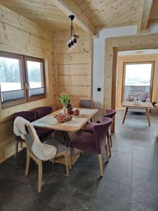 ein Esszimmer mit einem Tisch und lila Stühlen in der Unterkunft beskid house in Spytkowice
