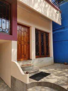 uma casa com duas portas e um piso de pedra em Sreevalsam Guest House em Trivandrum