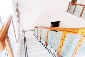 una escalera en una casa con barandilla de madera en Luxurious 5 BHK Duplex in Kukatpally en Hyderabad
