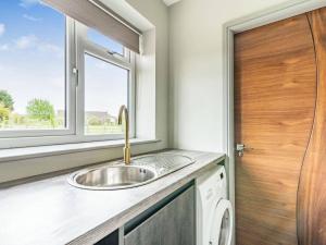 a kitchen with a sink and a window at Mya Cottage in Wilpshire