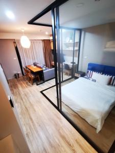 a bedroom with a bed and a desk in a room at Blossom condo in Yan Nawa