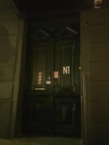 ソフィアにある"No party & Many rules" Hostel N1の看板付きの黒い扉