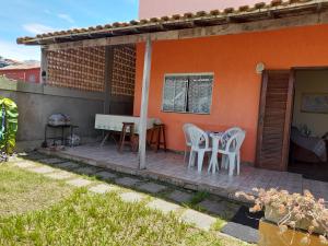 a patio with two white chairs and a table at Casa em Cabo Frio in Cabo Frio