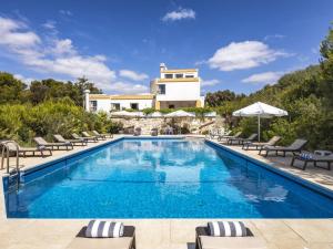 a swimming pool with chairs and a villa in the background at Villa Quinta Marinha - 9 bedroom villa 20 guests stunning location overlooking sea huge private p in Lagoa
