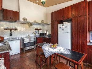 a kitchen with a table and a white refrigerator at Villa Quinta Marinha - 9 bedroom villa 20 guests stunning location overlooking sea huge private p in Lagoa