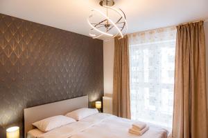 sypialnia z łóżkiem i dużym oknem w obiekcie Pastel Apartments w Braszowie