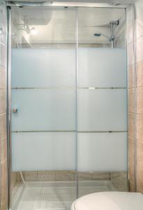 - Baño con aseo y puerta de ducha de cristal en Il Trulletto en Montalbano