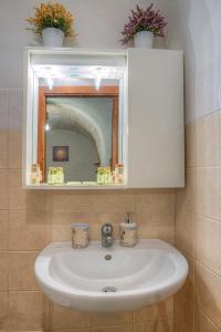 um lavatório branco na casa de banho com um espelho em Il Trulletto em Montalbano