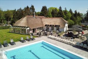 una casa con piscina frente a un edificio en Pool Lodge - Vakantiepark de Thijmse Berg en Rhenen