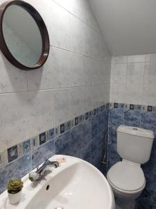 y baño con aseo, lavabo y espejo. en Стаи за гости Валеьови, en Bansko