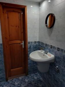 y baño con lavabo, aseo y espejo. en Стаи за гости Валеьови, en Bansko