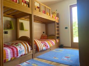 Dormitorio infantil con 2 literas y alfombra en Cavedago / Andalo con giardino, en Cavedago