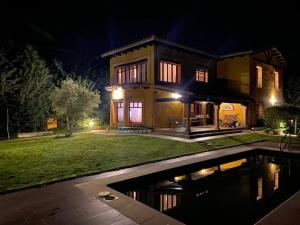 a house with a pool in front of it at night at Casa Mirador de Entrepeñas in Guadalajara