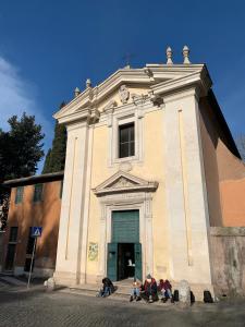 un grupo de personas sentadas frente a una iglesia en Appia Antica Guest House en Roma
