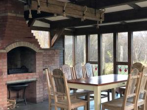a dining room with a table and chairs and a fireplace at Casa Boiereasca Bucovina in Gura Humorului