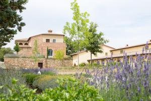 a garden with purple flowers in front of a building at Appartamento Quercia in Trequanda