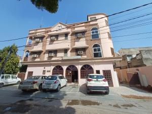 un edificio con auto parcheggiate di fronte di Hotel Raghav Palace 1 km Jaipur Junction & Bus Stand Sindhi Camp a Jaipur