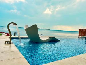 una piscina con una silla en el agua en Dana Beach Resort, en Bahía de la Media Luna