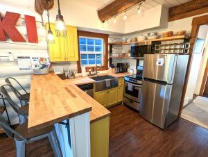 a kitchen with yellow cabinets and a stainless steel refrigerator at Black Bear Cabin 3 in Whitefish