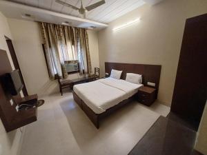 una camera con letto, sedia e televisore di Hotel Raghav Palace 1 km Jaipur Junction & Bus Stand Sindhi Camp a Jaipur