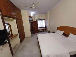um quarto com uma cama grande e uma televisão em Hotel Raghav Palace em Jaipur