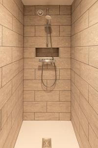 un bagno con doccia con piastrelle in legno di Le Manoir des Bréholles a Goustranville Altre 85 foto