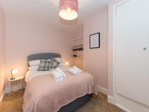 a bedroom with a bed with towels on it at Pass the Keys 3 Storey Townhouse in Shrewsbury