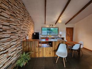 a kitchen and dining room with a brick wall at Cabañas Kainga in Hanga Roa
