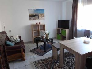 a living room with a table and a tv at Ferienwohnung am Ginkgo Baum in Bad Pyrmont