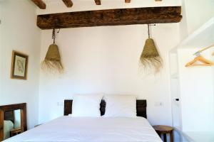 a bedroom with a white bed with two pillows at Romantico Apartamento en el Puerto de Denia in Denia