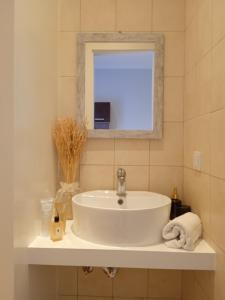 a bathroom with a white sink and a mirror at Aelia Boutique Apartments in Argostoli