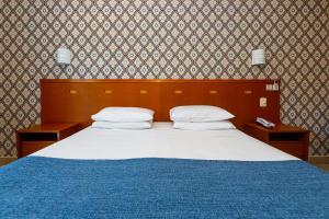 a bedroom with a large bed with a blue blanket at Panorama Hotel in Águas de Lindoia