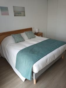 ein großes Bett mit einer grünen Decke drauf in der Unterkunft DOMITYS LES SALINES in Cherbourg en Cotentin