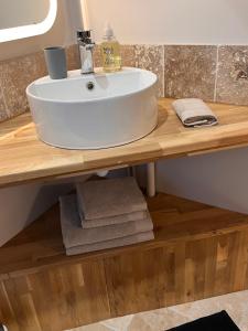a bathroom with a white sink on a wooden counter at Maisons d'hôtes du Château au Grand Pressigny in Le Grand-Pressigny