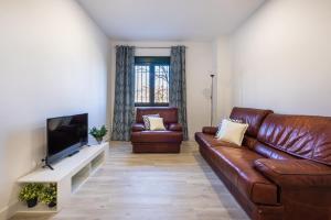 a living room with a leather couch and a flat screen tv at Apartamento Nueva Alcántara Beach in Marbella