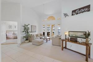 Una sala de estar con muebles blancos y chimenea. en Serene waterfront home with pool, spa, and water view, en Marco Island