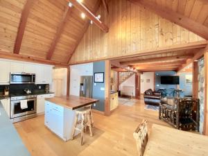 a large kitchen and living room with wooden ceilings at Brown Bear Chalet in Whitefish