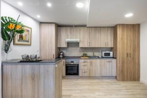 - une cuisine avec des placards en bois et un comptoir dans l'établissement Apartamento Nueva Alcántara Beach, à Marbella