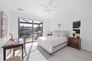 Un dormitorio con una cama y un escritorio y una ventana. en Serene waterfront home with pool, spa, and water view, en Marco Island 46 fotos más