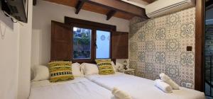 a bedroom with two beds and a window at PATRIMONIO ARABE VISTA A LA ALHAMBRA in Granada