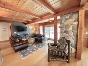 a living room with a large stone wall at Brown Bear Chalet in Whitefish