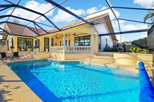 una piscina frente a una casa en Serene waterfront home with pool, spa, and water view, en Marco Island
