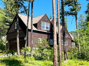 a house in the woods with trees at Brown Bear Chalet in Whitefish