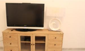 telewizor z płaskim ekranem siedzący na drewnianej szafce w obiekcie Amazing Sevilla Apartamento w Sewilli